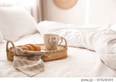 Delicious morning coffee and croissant on bed 97028504