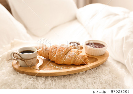 Delicious morning coffee and croissant on bed 97028505