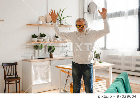 Senior man dance and using smartphone app for creating playlist music on mobile app - Elderly male having fun dancing with mobile phone technology - Tech and joyful elderly lifestyle concept 97029604