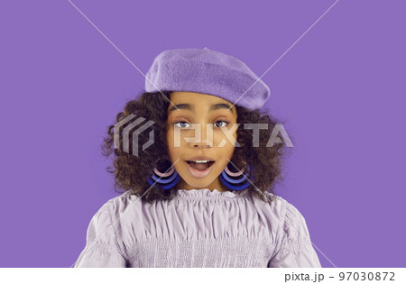 Black girl in purple beret and hoop earrings looking at camera with surprised face expression Black girl in purple beret and hoop earrings looking at camera with surprised face expression 97030872