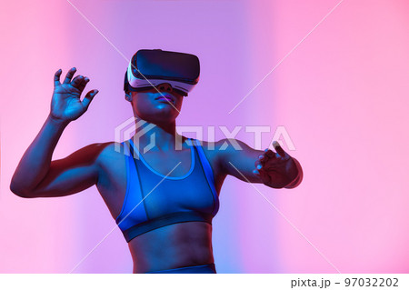 African american woman streamer playing video game using virtual reality glasses at gaming room 97032202