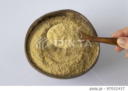 Nutritional yeast in a wooden bowl with spoon. Healthy vegan food concept. 97032437