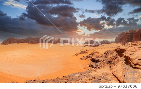 Red sands, mountains, dramatic sky and marthian landscape panorama of Wadi Rum desert, Jordan 97037006