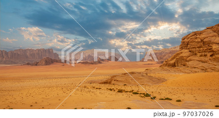 Red sands, mountains, dramatic sky and marthian landscape panorama of Wadi Rum desert, Jordan Red sands, mountains, dramatic sky and marthian landscape panorama of Wadi Rum desert, Jordan 97037026