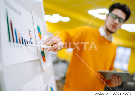 Young man leader, presenter, make a business presentation at a conference in the office. Young man leader, presenter, make a business presentation at a conference in the office. 97037079