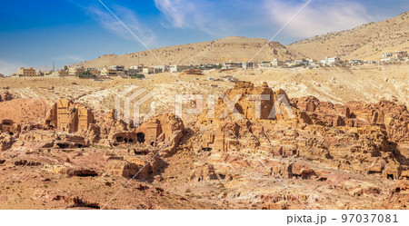 View to the ancient Nabataean Moghar Annasara tombs with Wadi Musa town in the background, Petra View to the ancient Nabataean Moghar Annasara tombs with Wadi Musa town in the background, Petra 97037081