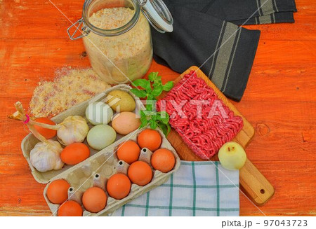 Minced meat, eggs, garlics and onion. Mixed minced meat ready to making burgers, fatty's, meaetballs. Food photography. Culinary concept. Minced meat recipe. Minced meat, eggs, garlics and onion. Mixed minced meat ready to making burgers, fatty's, meaetballs. Food photography. Culinary concept. Minced meat recipe. 97043723