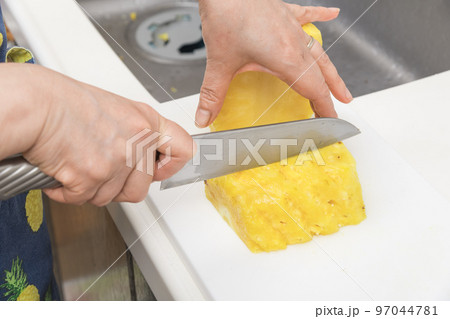 【皮削ぎの終わったパイナップルを切っていく】 【皮削ぎの終わったパイナップルを切っていく】 97044781