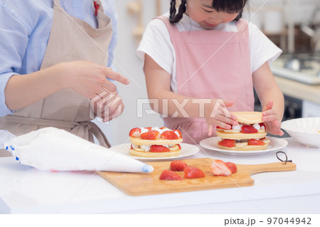 ファミリー　パンケーキを作る女の子とママの手元 97044942
