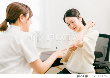 整形外科でテニス肘・上肘の怪我をして悩む患者とカウンセリング・診察・問診する医師・看護師・カウンセラ 整形外科でテニス肘・上肘の怪我をして悩む患者とカウンセリング・診察・問診する医師・看護師・カウンセラ 97045470