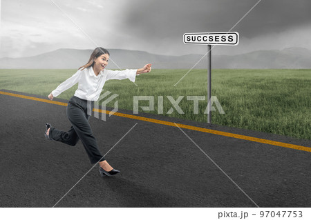 Asian businesswoman running on the street with a success sign Asian businesswoman running on the street with a success sign 97047753