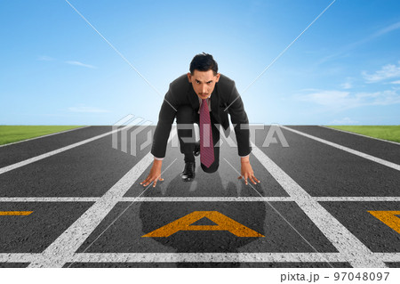 Asian businessman in start position ready to run 97048097