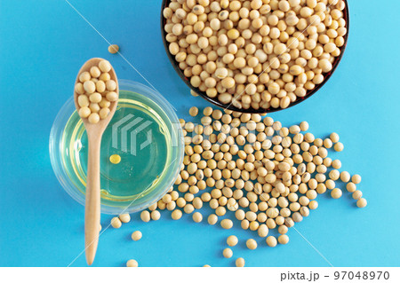 soybean and oil in a bowl on blue background, top view, flat lay, top-down, selective focus.copy space.flat lay,top down,top view. 97048970