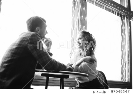 close up. loving couple sitting at a table in a cozy cafe. black and white photo close up. loving couple sitting at a table in a cozy cafe. black and white photo 97049547