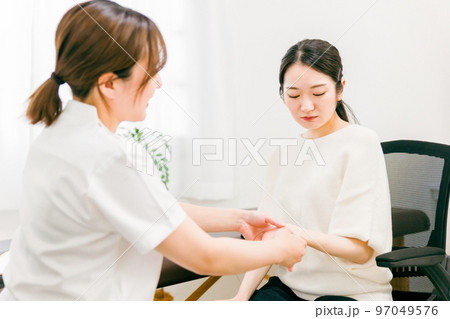 整形外科で腱鞘炎・親指の怪我をして悩む患者とカウンセリング・診察・問診する医師・看護師・カウンセラー 整形外科で腱鞘炎・親指の怪我をして悩む患者とカウンセリング・診察・問診する医師・看護師・カウンセラー 97049576