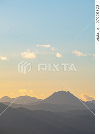 淡いグラデーションの空と山の稜線のシルエット。北海道の雄阿寒岳。 淡いグラデーションの空と山の稜線のシルエット。北海道の雄阿寒岳。 97050322