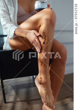 Young woman applying natural scrub on her body, close view 97052538