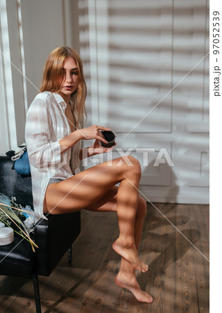 Young woman applying natural scrub on her body at home Young woman applying natural scrub on her body at home 97052539