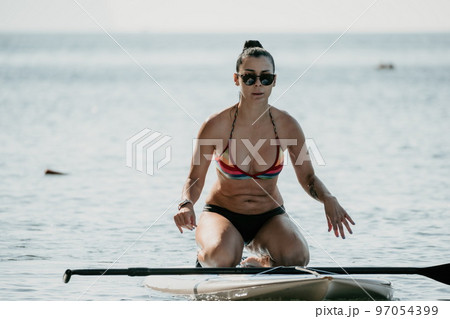 Sea woman sup. Silhouette of happy middle aged woman in rainbow Sea woman sup. Silhouette of happy middle aged woman in rainbow 97054399
