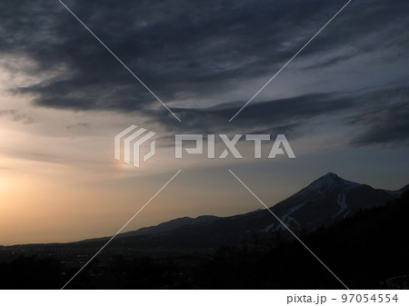 早春の夕暮れ時、夕日で虹色の雲が出現し、冠雪の磐梯山とのコラボレーションが綺麗 97054554