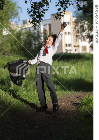 A happy schoolboy throws up his school backpack and rejoices at the start of the holidays. The end of the school year and the beginning of the holidays. 97054598