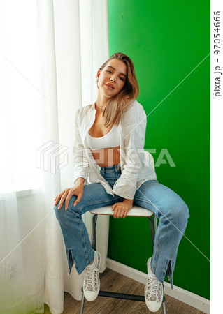 Portrait of attractive lovely girl wearing crop top and shirt posing over green studio background Portrait of attractive lovely girl wearing crop top and shirt posing over green studio background 97054666