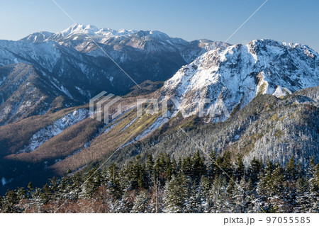 晴天の下で長野と岐阜の県境の西穂高岳稜線から見るアルプスの稜線　朝焼けする北アルプスの山々 97055585
