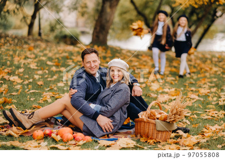 A big family on a picnic in the fall in a nature park. Happy people in the autumn park A big family on a picnic in the fall in a nature park. Happy people in the autumn park 97055808