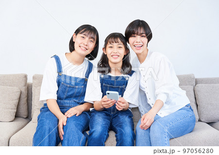 ソファーに座る姉妹と母親 97056280