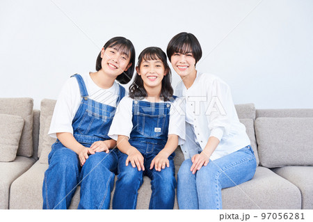 ソファーに座る姉妹と母親 ソファーに座る姉妹と母親 97056281