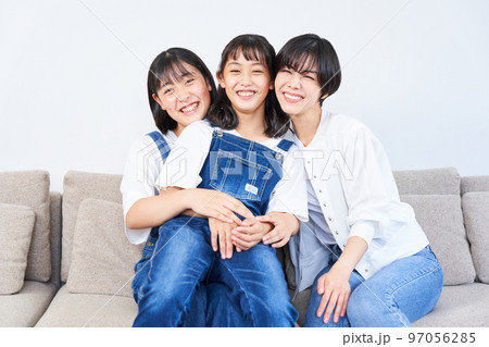 ソファーに座る姉妹と母親 ソファーに座る姉妹と母親 97056285