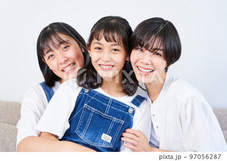 ソファーに座る姉妹と母親 97056287