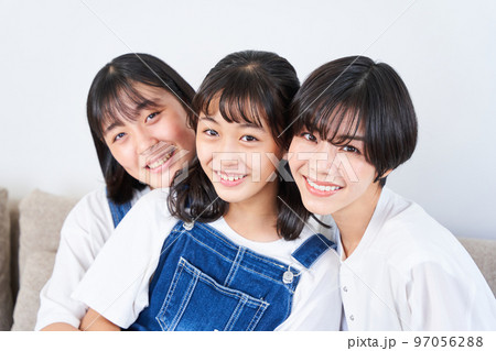 ソファーに座る姉妹と母親 97056288