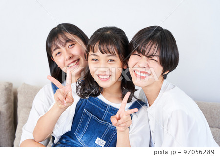 ソファーに座る姉妹と母親 ソファーに座る姉妹と母親 97056289