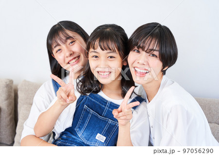 ソファーに座る姉妹と母親 ソファーに座る姉妹と母親 97056290