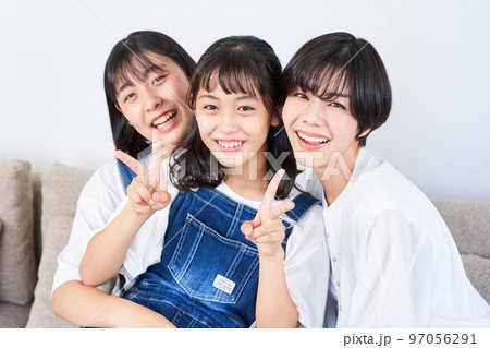 ソファーに座る姉妹と母親 ソファーに座る姉妹と母親 97056291