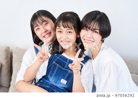 ソファーに座る姉妹と母親 97056292