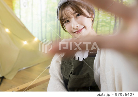 アウトドアチェアにに座って手を振る若い女性 家キャン おうちキャンプ キャンプイメージ アウトドアチェアにに座って手を振る若い女性 家キャン おうちキャンプ キャンプイメージ 97056407