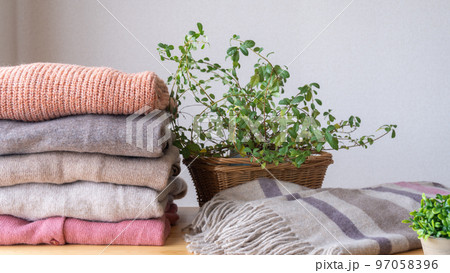 たたまれた冬物の服とマフラー｜洗濯物・衣替えイメージ 97058396