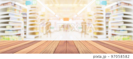Wood table top with supermarket grocery store aisle interior blurred background with bokeh light for product display Wood table top with supermarket grocery store aisle interior blurred background with bokeh light for product display 97058582