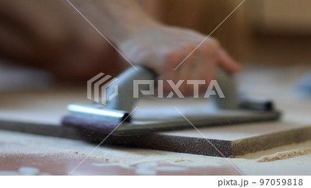 Carpenter grinders sanding wooden board. Close up of hands Carpenter grinders sanding wooden board. Close up of hands 97059818