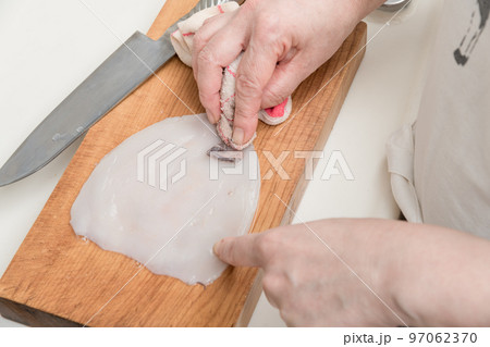 【ミドル主婦がスルメイカをさばく　布巾で胴体の皮を剥ぐ】 97062370