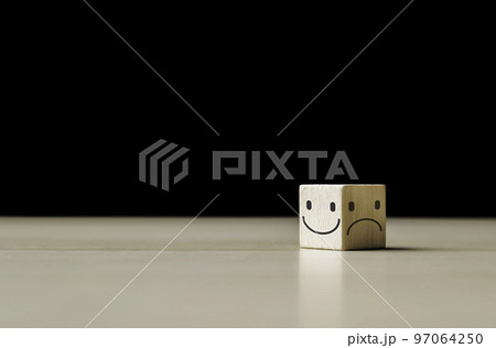 Smile face on the bright side and sad face in dark side on the wooden block cube for positive mindset selection. Mental health and emotional state concept, choice satisfaction feedback emotional. Smile face on the bright side and sad face in dark side on the wooden block cube for positive mindset selection. Mental health and emotional state concept, choice satisfaction feedback emotional. 97064250