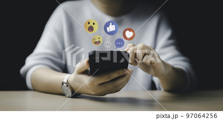 Women use smart phone to play on social media. Social Distancing, Working From Home concept. The concept of living on and playing media communication. Chat with friends and send emotion icons. 97064256