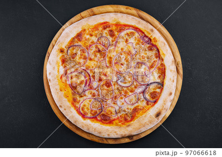 Pizza with tuna and red onion on wooden cutting board 97066618