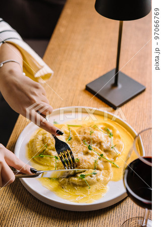 woman eating ravioli with parmesan cheese 97066769