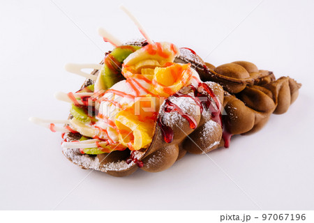 Egg waffle with ice cream and fruits with syrup 97067196