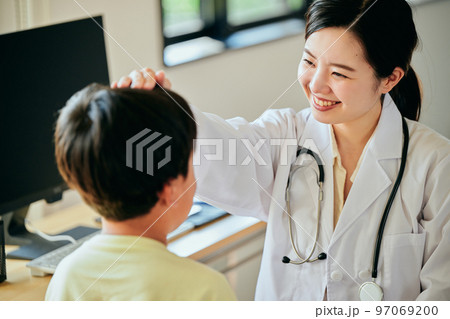 小学生の男の子を診察する若い女性医師 小学生の男の子を診察する若い女性医師 97069200