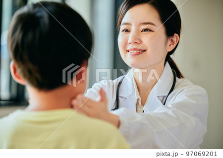 小学生の男の子を診察する若い女性医師 97069201
