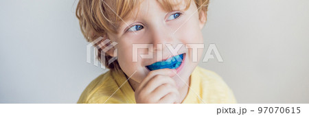 Three-year old boy shows myofunctional trainer to illuminate mouth breathing habit. Helps equalize the growing teeth and correct bite. Corrects the position of the tongue BANNER, long format 97070615